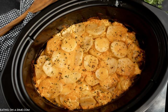Close up image of scalloped potatoes in the crock pot. 