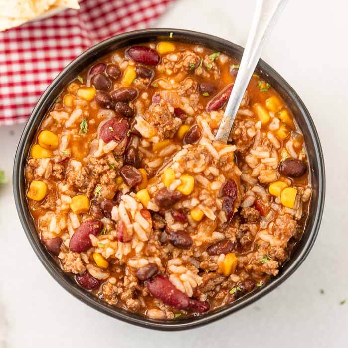 Bowl of Crockpot Taco Rice Soup with a spoon.