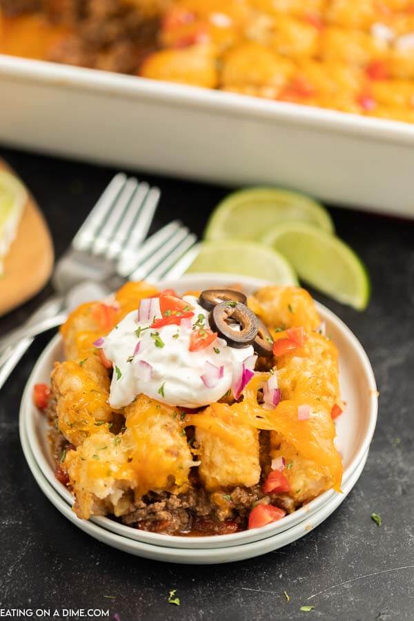 Close up image of beef enchilada tator tot casserole on a white plate. 
