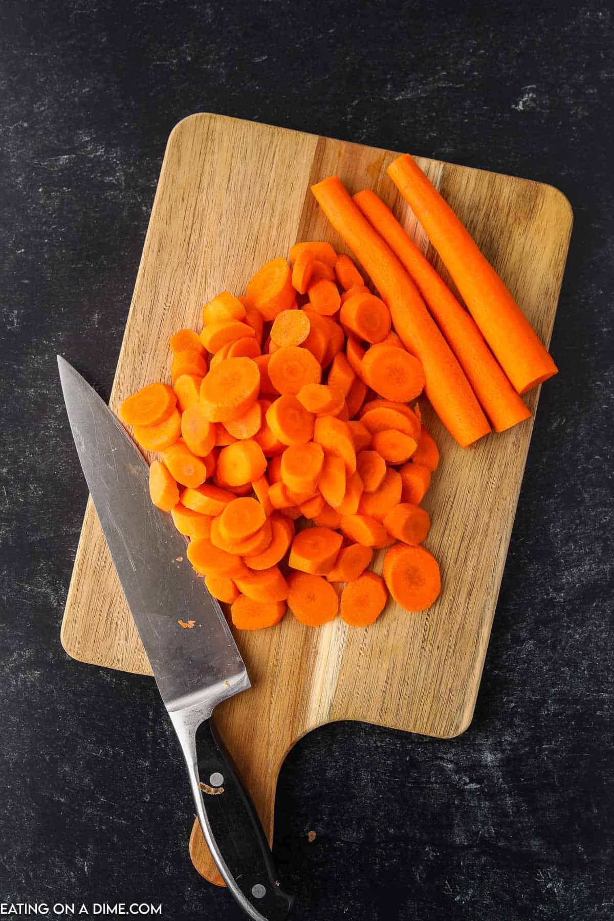 Trim and cut carrots on a cutting board with knife