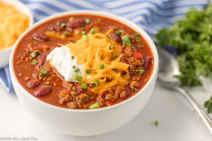 Bowl of cowboy chili topped with sour cream and cheese. 