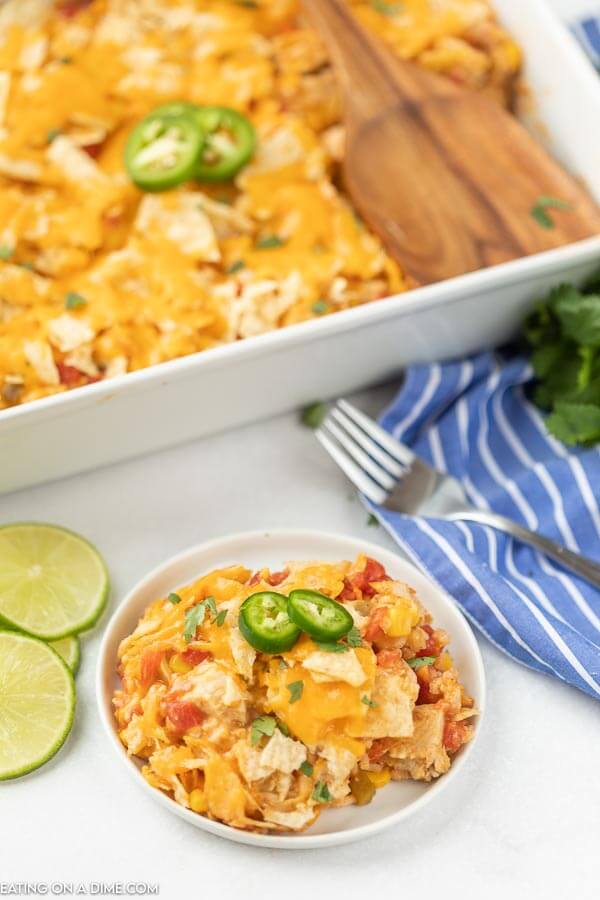 Nacho Chicken Casserole Recipe in a white baking dish with a white plate in front of it with chicken casserole.