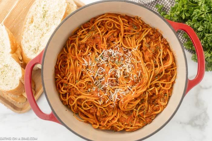 Close up image of a pot of spaghetti with a side of French Bread. 