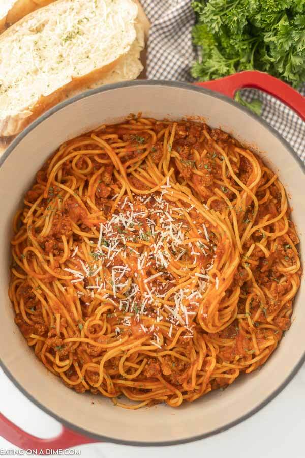 Close up image of a pot of spaghetti with a side of french bread. 