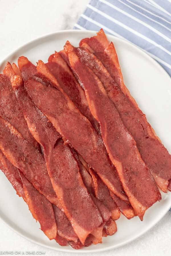 Close up image of cooked turkey bacon on a white plate. 