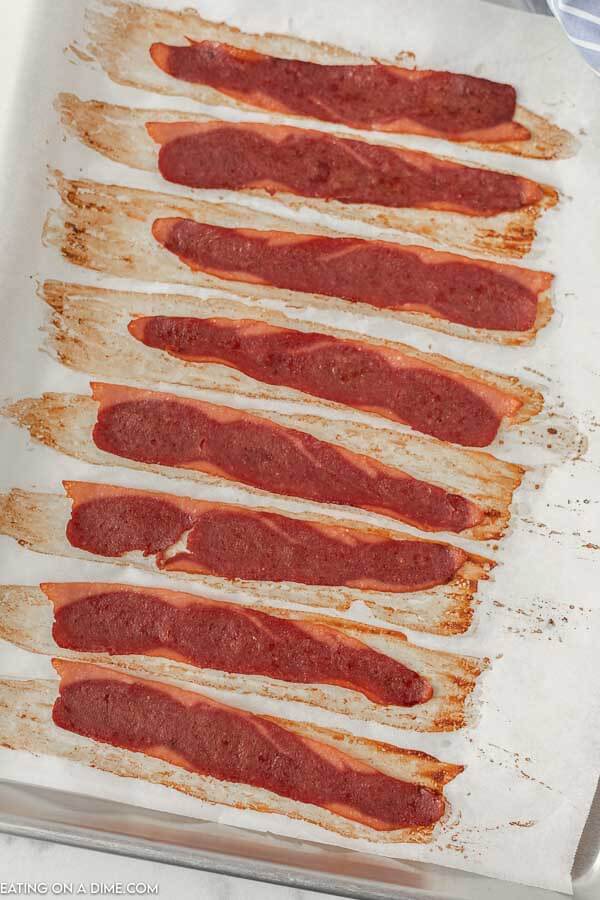 Close up image of cooked turkey bacon on a baking sheet. 