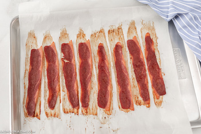 Close up image of cooked turkey bacon on a baking sheet. 