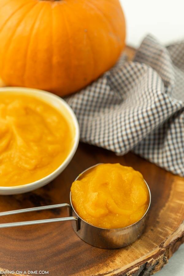 bowl of pumpkin puree beside a measuring cup