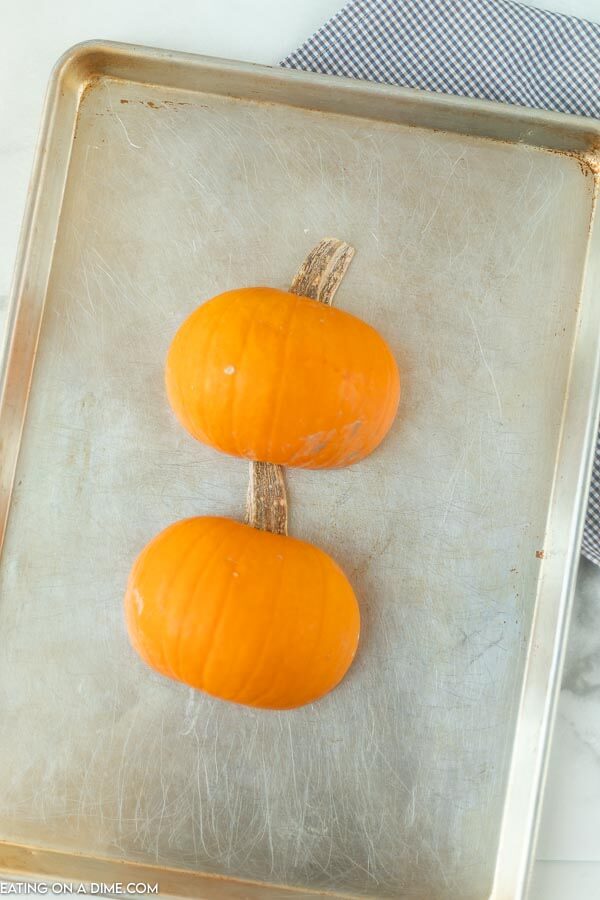 pumpkin halves on baking sheet ready to be cooked.