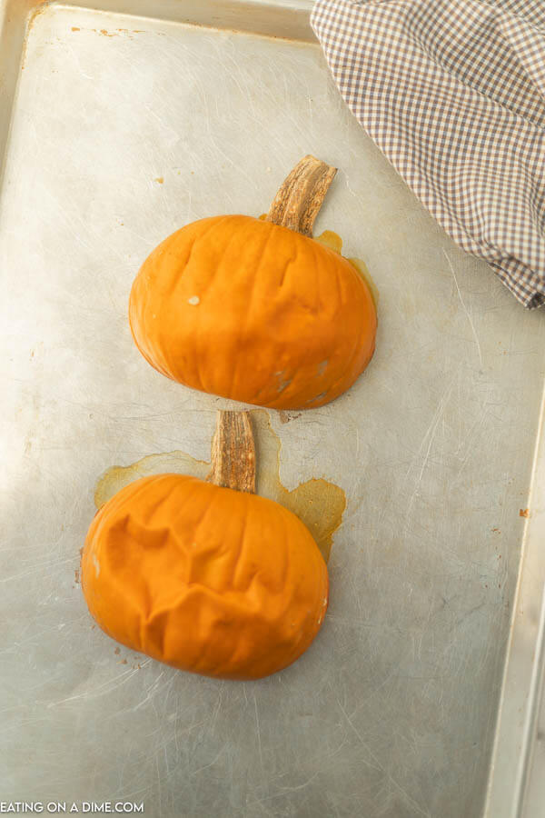 cooked pumpkin halves on baking sheet