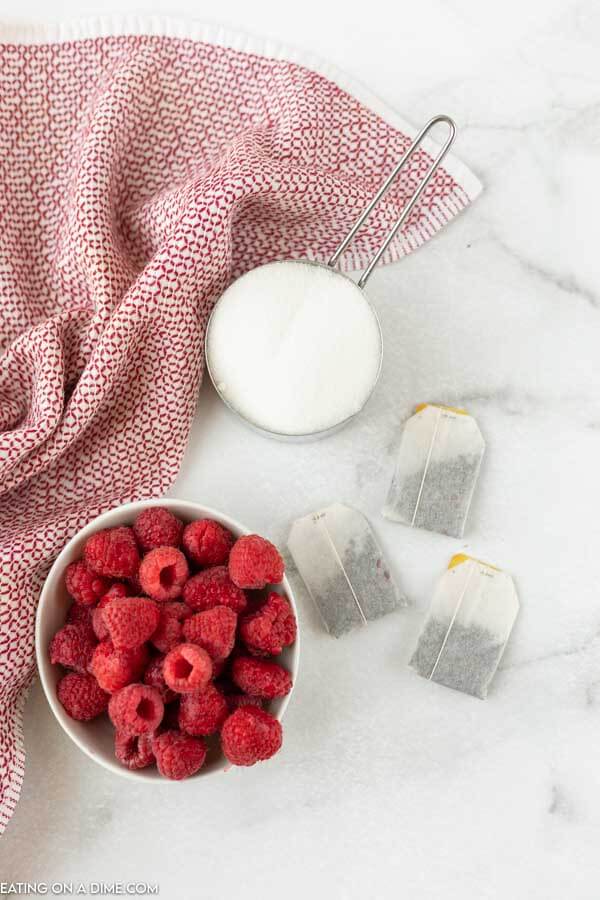 Ingredients needed for raspberry tea - sugar, raspberries, and tea bags. 