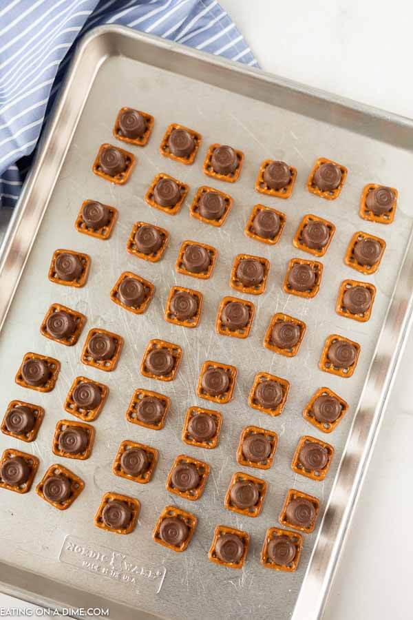 Close up image of Rolo Pretzel Bites in process on a cookie sheet. 