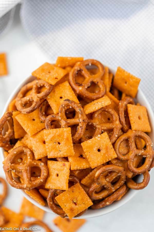 Close up image of cheez it snack mix in a white bowl. 