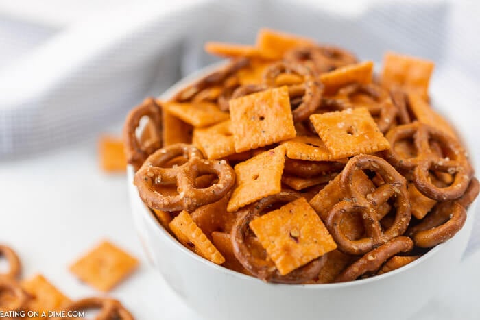 Close up image of spicy cheez it snack mix in a white bowl. 