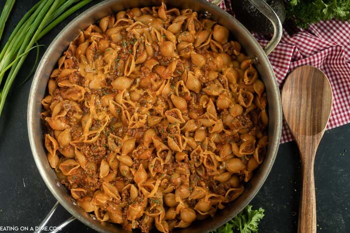 Close up image of taco pasta in a saucepan with a wooden spoon. 