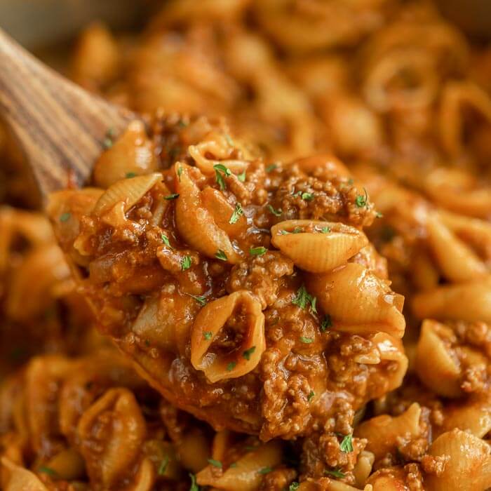 Close up image of taco pasta on a wooden spoon.