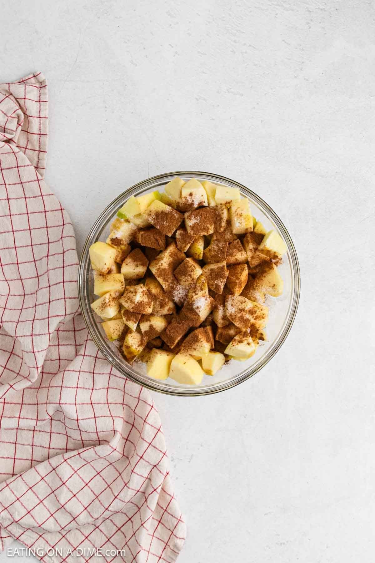 Diced apples in a bowl top with cinnamon and sugar. 