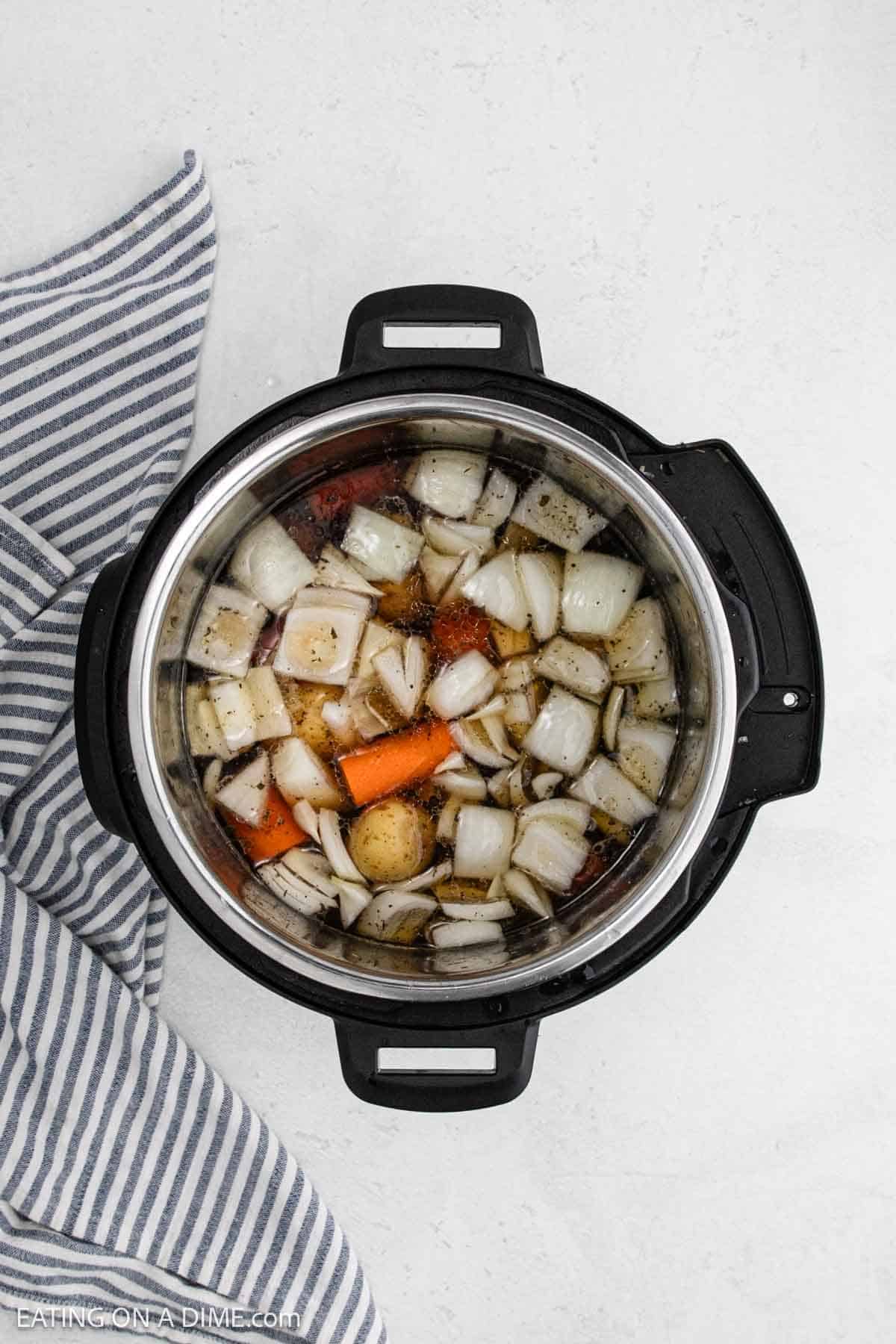 Chopped onions, carrots, and potatoes added to the instant pot.