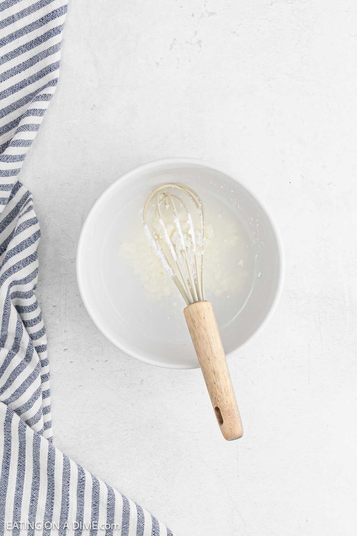 Whisking cornstarch and water together in a bowl.