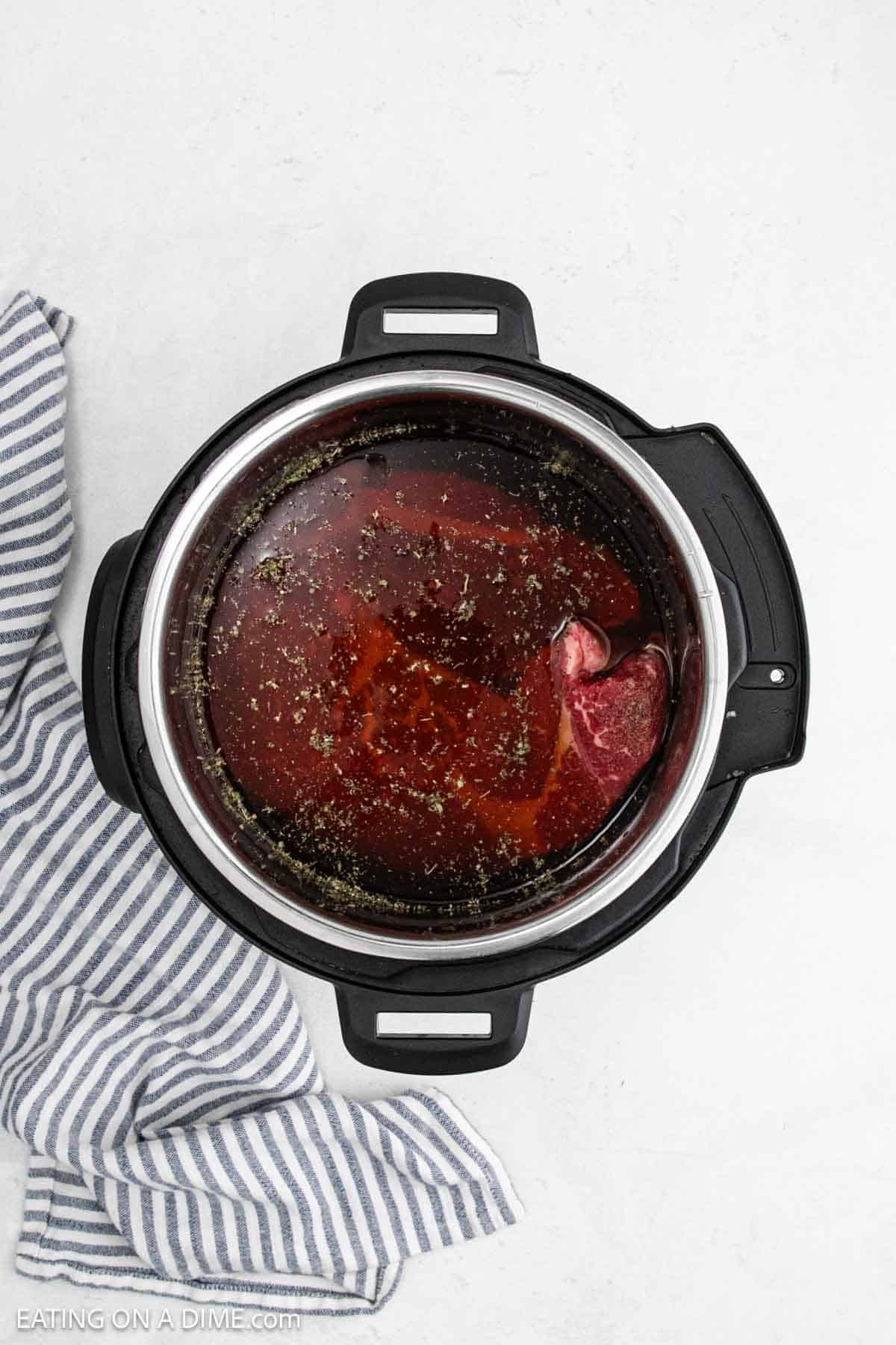 Broth added to the instant pot with the seasoned roast.