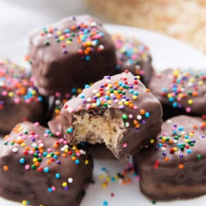 A close-up of chocolate covered rice krispie treats topped with colorful sprinkles.