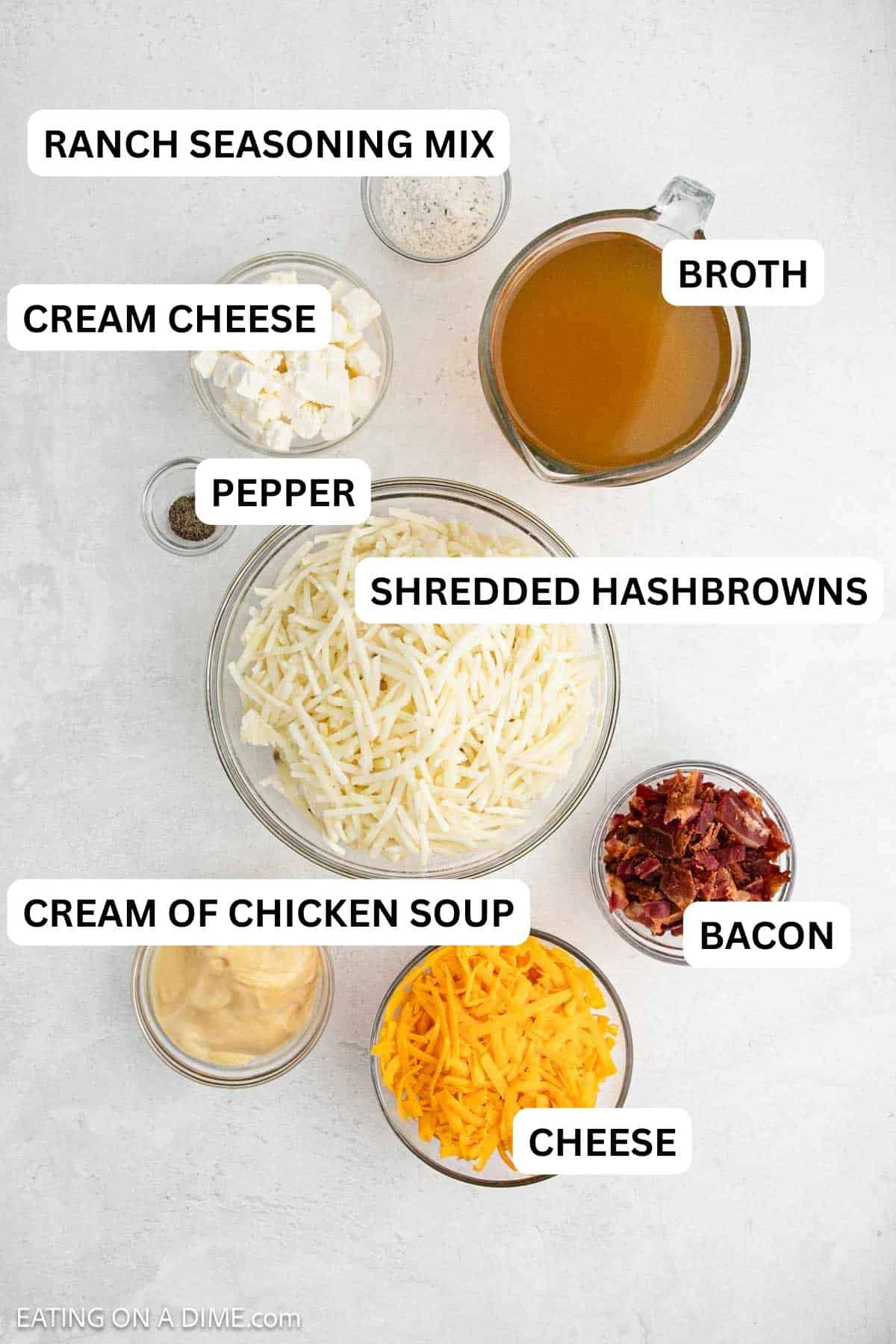 Ingredients needed for this recipe includes frozen shredded hashbrowns, cream of chicken soup, pepper, ranch seasoning mix, broth, bacon, cream cheese and cheese.