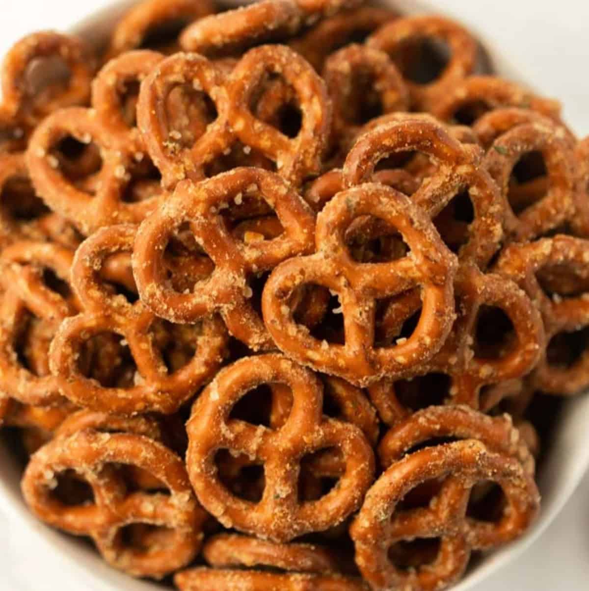 A close-up of a bowl filled with small, salted pretzels, showing their golden-brown, crunchy texture and coarse salt sprinkled on top—perfect for trying your favorite garlic ranch pretzels recipe.