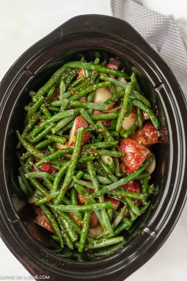 Close up image of Italian Chicken with green beans and red potatoes in a crock pot. 