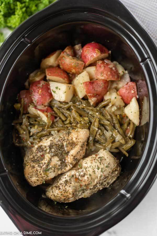 Close up image of Italian Chicken with green beans and red potatoes in a crock pot. 