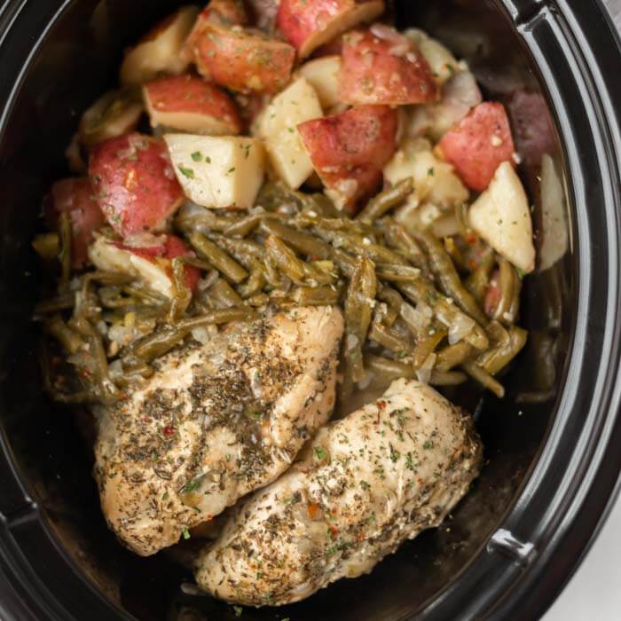 Close up image of Italian Chicken with green beans and red potatoes in a crock pot. 