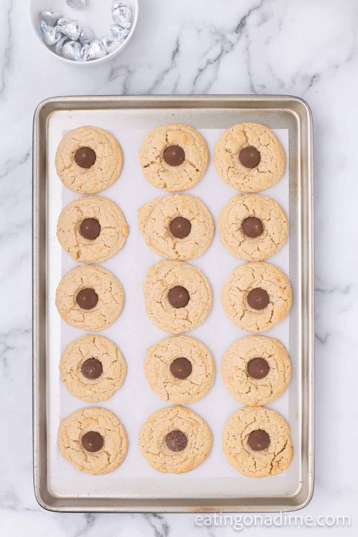 Top cookies with Hershey Kiss on a baking sheet