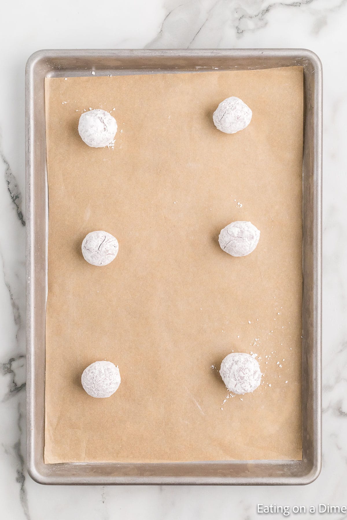 Rolled red velvet cookie dough on baking sheet