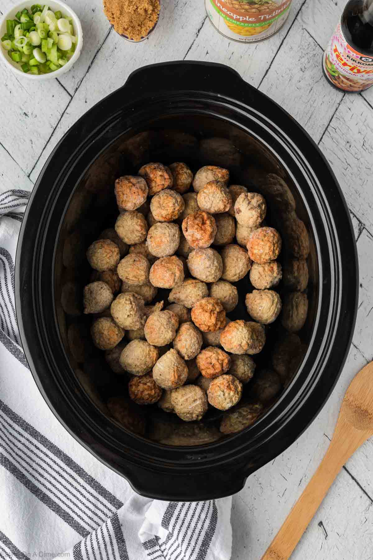 Placing meatballs in the slow cooker
