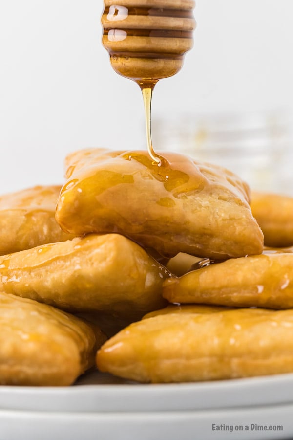 Close up image of sopapillas drizzled with honey. 