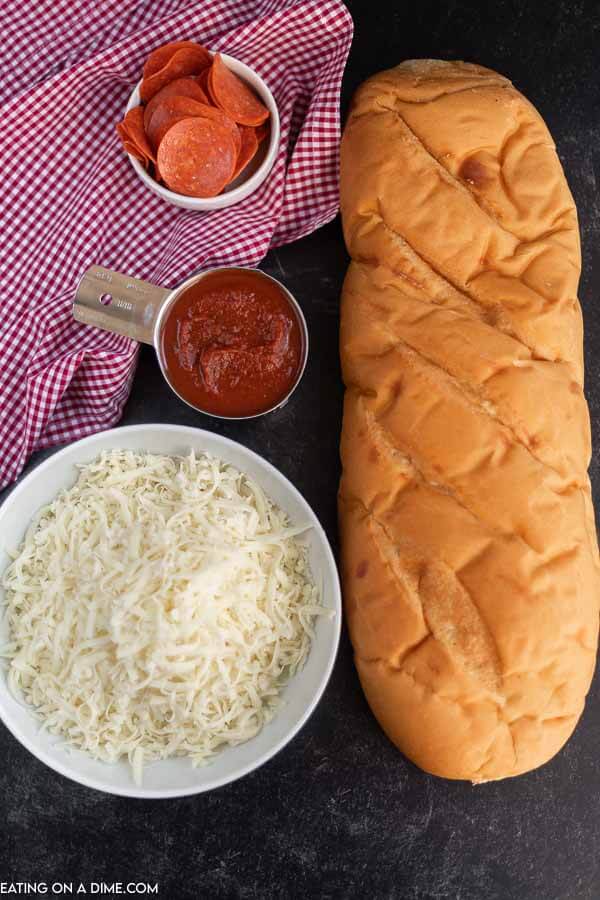 Close up image of Ingredients needed for Air Fryer French Bread Pizza - French Bread, Mozzarella, Pizza Sauce, and Pepperoni.  