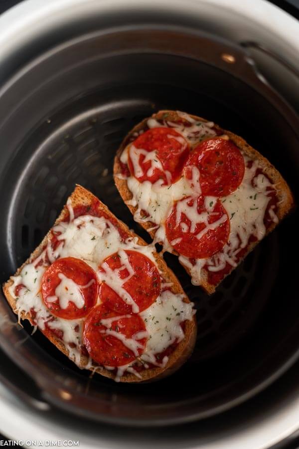 Close up image of french bread pizza in the air fryer. 