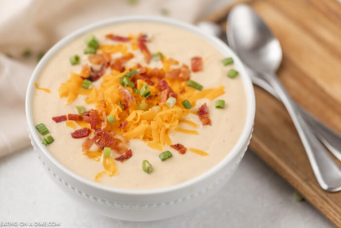 Bowl of cauliflower soup topped with cheese and bacon. 