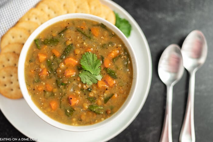 Bowl of lentil soup beside crackers. 