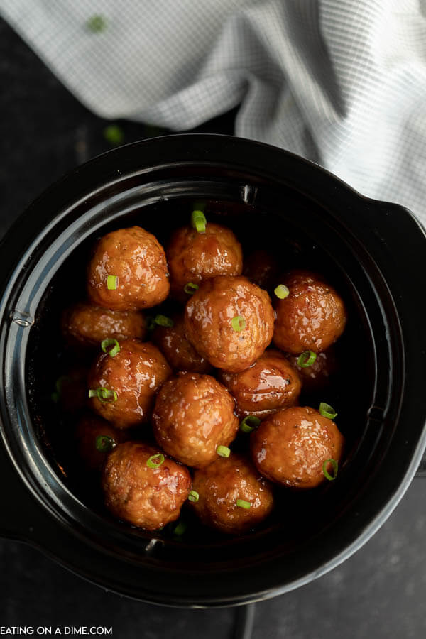 Close up image of sweet and spicy meatballs in the crock pot. 