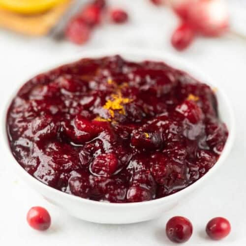 Cranberry Sauce topped with zest in a white bowl.