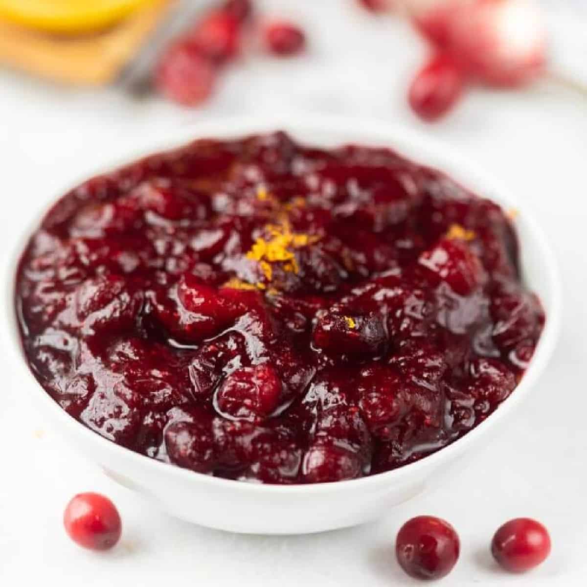 Cranberry Sauce topped with zest in a white bowl.