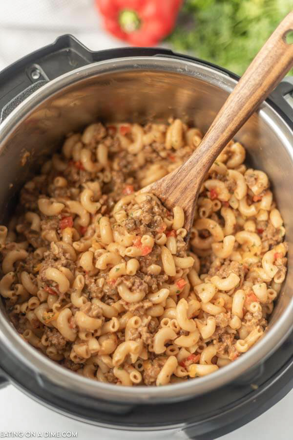 instant pot hamburger helper with a wooden spoon in it. 