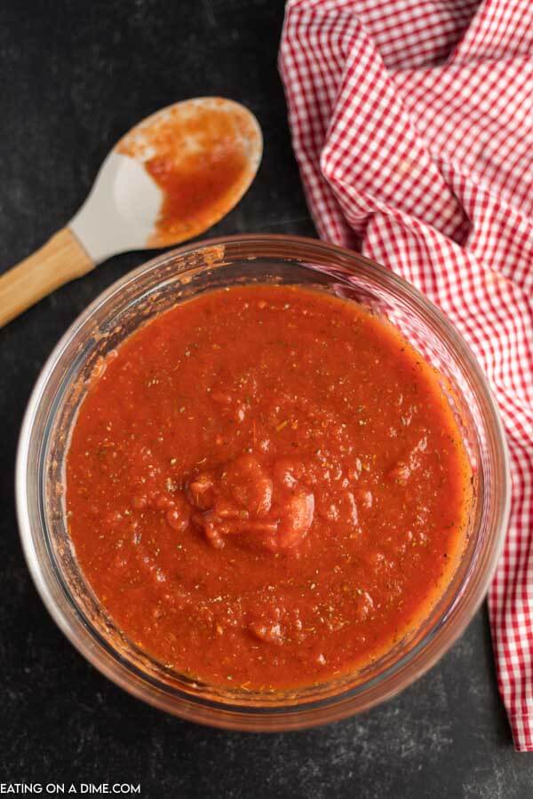 Close up image of the tomato sauce mixture in a clear bowl with a spoon. 