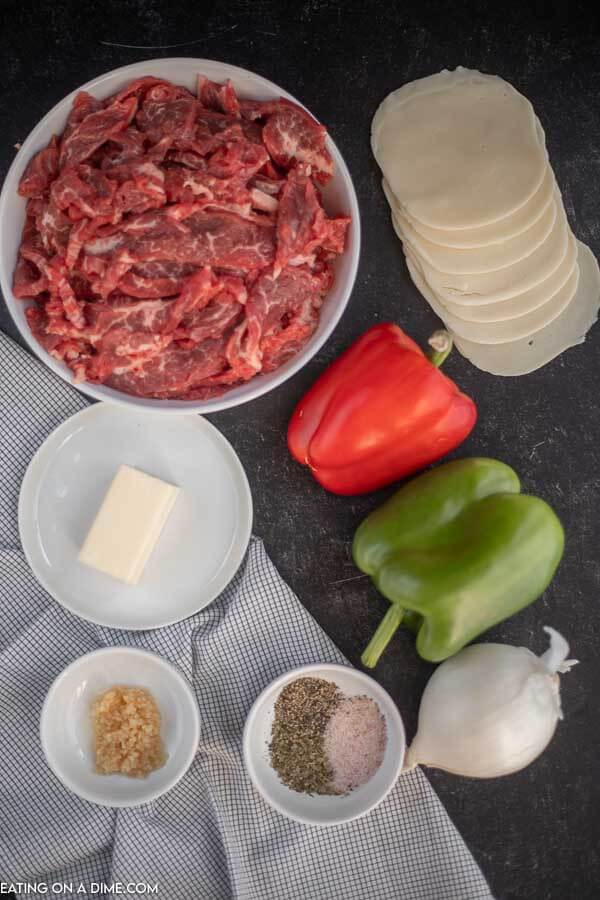 Ingredients for philly cheesesteak - flank steak, minced garlic, green bell pepper, butter, red bell pepper, onion, provolone cheese, italian seasoning, salt and pepper. 
