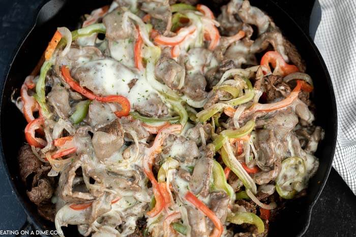 Close up image of philly cheesesteak in a skillet. 