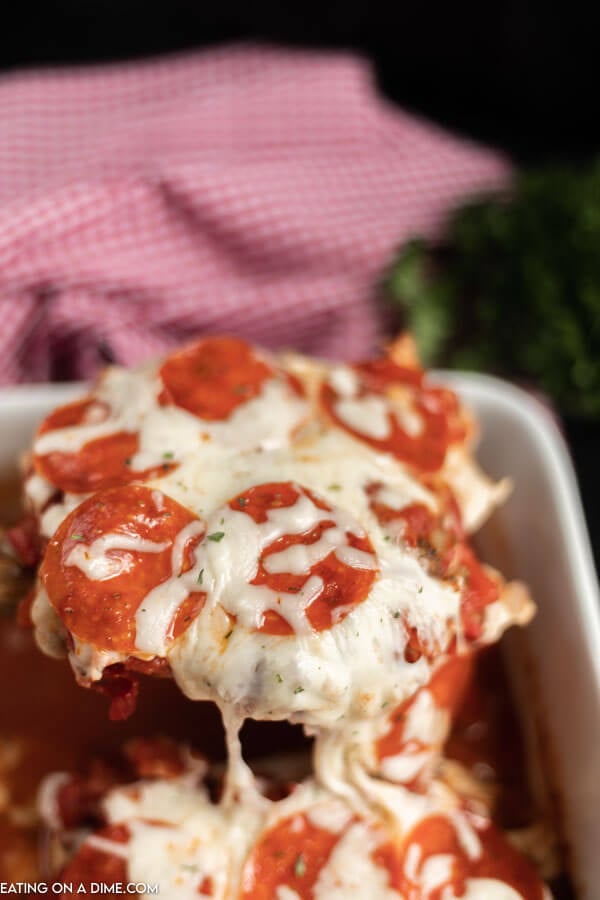 Close up image of pizza chicken being served out of the pan. 
