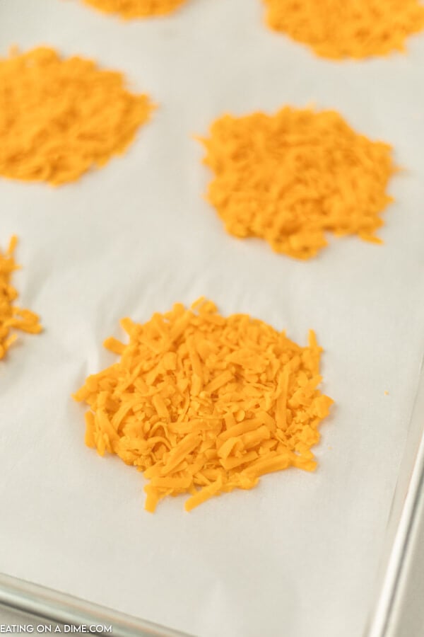 Close up image of grated cheese piles on a baking sheet. 