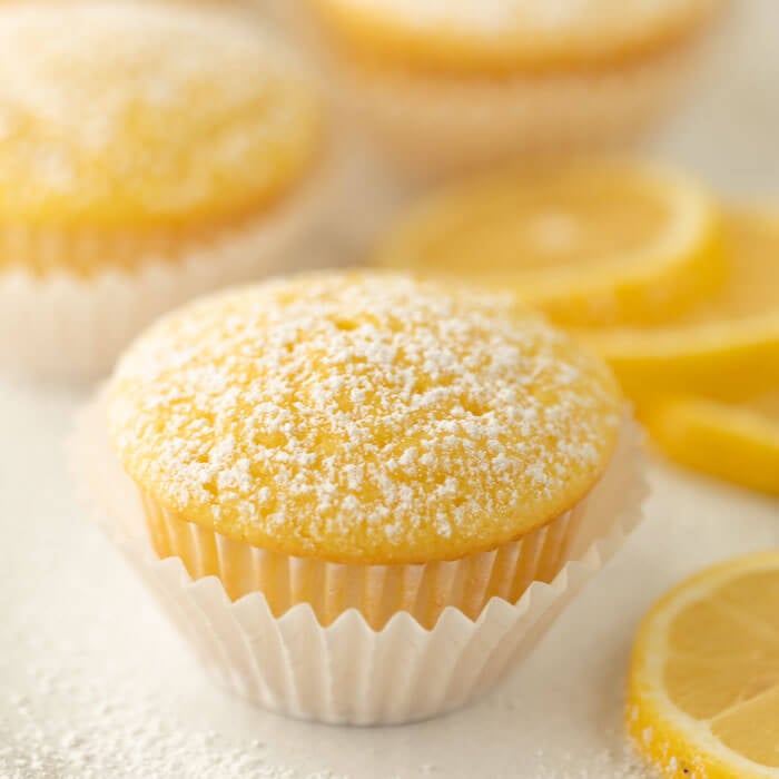 Close up image of Lemon Cupcake with Lemon slices in the background. 