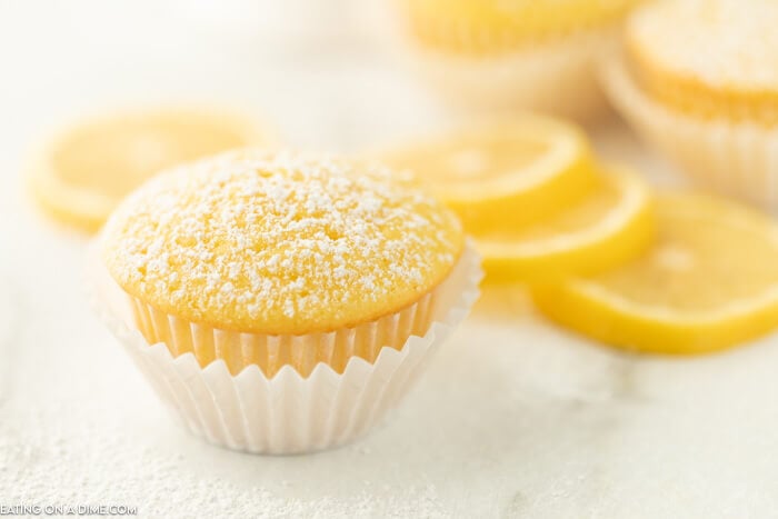 Close up image of Lemon Cupcake with Lemon slices in the background. 