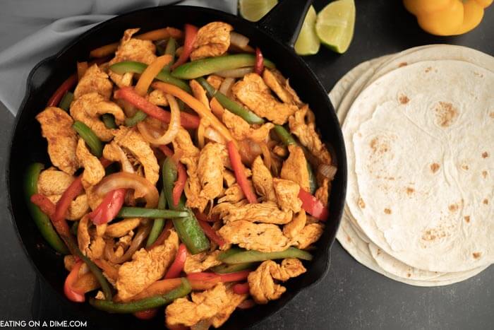 Cast iron skillet of chicken strips, bell peppers and onion. 